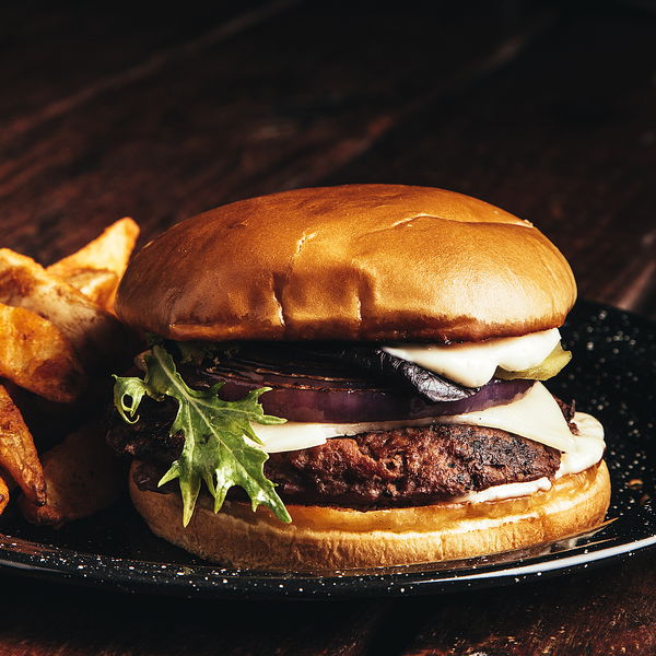 Hamburguesa con arúgula fresca y cebolla morada en pan brioche