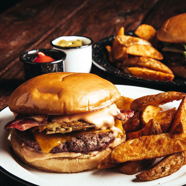 Hamburguesa doble con papas gajo y aderezos de la casa